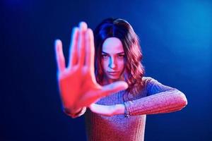 ritratto di giovane ragazza con Riccio capelli nel rosso e blu neon nel studio foto