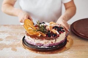 vicino su Visualizza di donna con fresco dietetico torta su il cucina foto