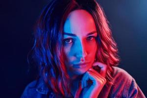 ritratto di giovane ragazza con Riccio capelli nel rosso e blu neon nel studio foto