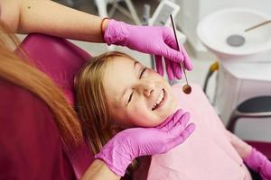 poco ragazza visitare dentista nel clinica. concezione di stomatologia foto