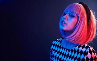 ritratto di giovane ragazza con biondo capelli nel rosso e blu neon nel studio foto