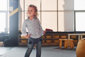 bambino nel casuale Abiti avere divertimento nel stanza dei giochi a fine settimana tempo foto