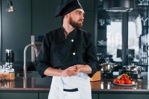 ritratto di professionale giovane capocuoco cucinare nel uniforme quello in posa per telecamera su il cucina foto