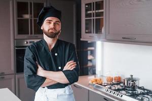 professionale giovane capocuoco cucinare nel uniforme in piedi su il cucina foto