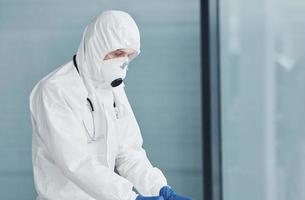 maschio medico scienziato nel laboratorio cappotto, difensiva occhiali e maschera foto