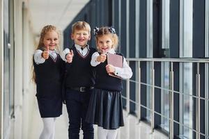 scuola bambini nel uniforme insieme nel corridoio. concezione di formazione scolastica foto