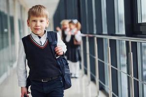 scuola bambini nel uniforme insieme nel corridoio. concezione di formazione scolastica foto