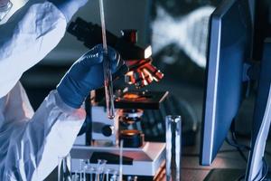 scienziato nel bianca protettivo uniforme lavori con coronavirus e sangue tubi nel laboratorio foto