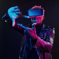 virtuale la realtà Esperienza. futuristico neon illuminazione. giovane africano americano uomo nel il studio foto