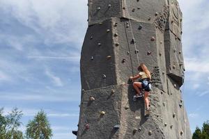 poco ragazza nel casuale bianca Abiti formazione roccia arrampicata all'aperto foto