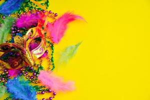 carnevale maschera con piume su giallo sfondo. multicolore perline mardi gras o Grasso martedì simbolo. foto