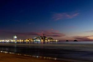 mazatlàn sinaloa spiaggia a notte con luminoso città nel il sfondo foto