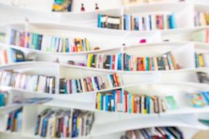 sfocato Immagine di molti libri su curvo scaffale nel biblioteca sfondo. foto