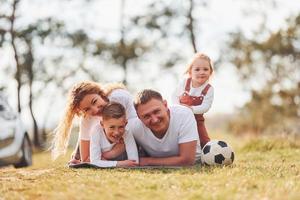 contento famiglia la spesa fine settimana insieme all'aperto vicino il foresta. con figlia e figlio foto