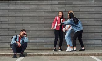 tre donne in piedi e ridendo a tipo quello seduta all'aperto vicino edificio a giorno foto