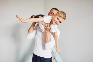 Tenere ragazzo nel mani. padre e il suo giovane giovane la spesa tempo insieme in casa vicino tenda foto