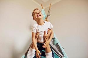 Tenere ragazzo nel mani. padre e il suo giovane giovane la spesa tempo insieme in casa vicino tenda foto