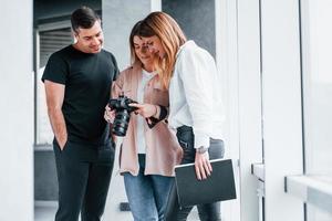 gruppo di persone in piedi in casa insieme e sembra a fotografie su telecamera