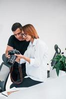 uomo nel nero Abiti Guardando fotografie su il femminile fotografo telecamera