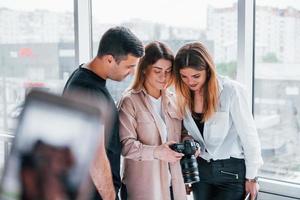 gruppo di persone in piedi in casa insieme e sembra a fotografie su telecamera