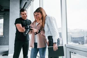 gruppo di persone in piedi in casa insieme e sembra a fotografie su telecamera