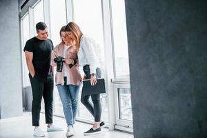 gruppo di persone in piedi in casa insieme e sembra a fotografie su telecamera