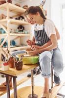 con sua fidanzato o marito. giovane femmina ceramista avere un' lavori in casa con fatto a mano argilla Prodotto. concezione di ceramica foto