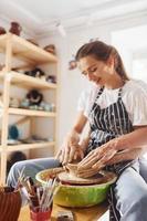 con sua fidanzato o marito. giovane femmina ceramista in casa con fatto a mano argilla Prodotto. concezione di ceramica foto