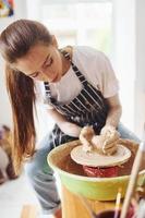 giovane femmina ceramista Lavorando di utilizzando ceramica ruota in casa e fabbricazione fatto a mano argilla Prodotto foto