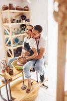 con sua fidanzato o marito. giovane femmina ceramista avere un' lavori in casa con fatto a mano argilla Prodotto. concezione di ceramica foto