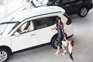 madre con sua figlia a piedi insieme vicino moderno automobile in casa foto