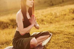 giovane donna avendo un' riposo e fare yoga esercizi all'aperto nel il montagne foto