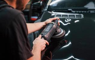 tipo lucidatura superficie di veicolo. moderno nero automobile ottenere puliti di uomo dentro di auto lavare stazione foto