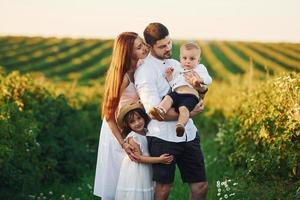 padre, madre con figlia e figlio la spesa gratuito tempo all'aperto a soleggiato giorno tempo di estate foto