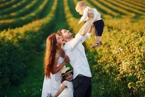 padre, madre con figlia e figlio la spesa gratuito tempo all'aperto a soleggiato giorno tempo di estate foto