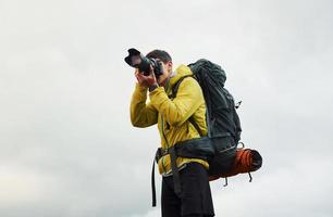 giovane maschio fotografo con il suo professionale telecamera assunzione immagini di bellissimo natura foto