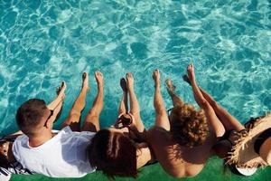superiore Visualizza di gruppo di giovane contento persone quello avere divertimento nel nuoto piscina a giorno foto
