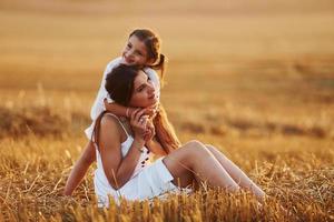 contento madre con sua poco figlia la spesa tempo insieme all'aperto su il campo foto