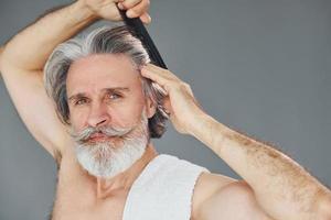 bellissimo ritratto. elegante moderno anziano uomo con grigio capelli e barba è in casa foto