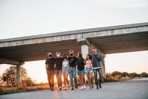 Abbracciare una persona ogni Altro. gruppo di giovane allegro amici avendo divertimento insieme. festa all'aperto foto