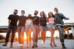 Abbracciare una persona ogni Altro. gruppo di giovane allegro amici avendo divertimento insieme. festa all'aperto foto