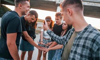 parlando e ridendo. gruppo di giovane allegro amici avendo divertimento insieme. festa all'aperto foto