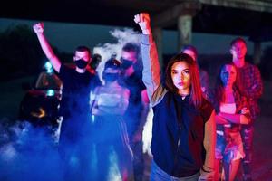 Fumo, pugni, Polizia Stradale. gruppo di protestare giovane persone quello in piedi insieme. attivista per umano diritti o contro governo foto