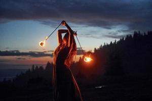 fuoco mostrare di donna nel vestito nel notte carpaziano montagne. bellissimo paesaggio foto