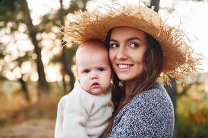 giovane madre con sua poco bambino riposa all'aperto a autunno stagione foto