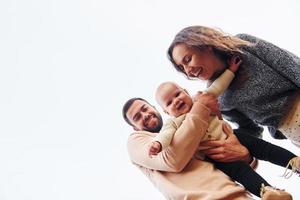 Visualizza a partire dal sotto. contento famiglia di madre, famiglia e poco bambino riposa all'aperto. bellissimo soleggiato autunno natura foto