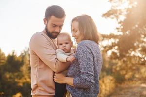 contento famiglia di madre, famiglia e poco bambino riposa all'aperto. bellissimo soleggiato autunno natura foto