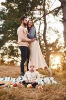 ha picnic. contento famiglia di madre, famiglia e poco bambino riposa all'aperto. bellissimo soleggiato autunno natura foto