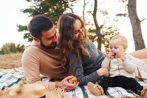 ha picnic. contento famiglia di madre, famiglia e poco bambino riposa all'aperto. bellissimo soleggiato autunno natura foto