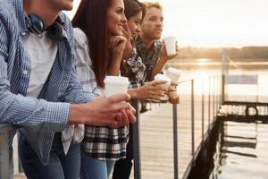 vicino il lago. gruppo di giovane allegro amici quello è all'aperto avendo divertimento insieme foto